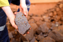 Close Up Picture Of Scientist Geologist Hands Inspecting Exploration On Iron Ore Rock On Open Field Mine Site, Perth, Australia 
