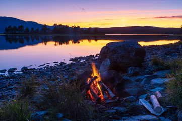 Fototapete - A campfire at the shore of a lake in Scandinavia. Jamtland, Sweden.
