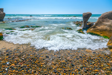 Wall Mural - Rocks and mosses on the beach when waves hit create a vivid beauty