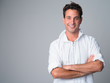 © Ranta Images - Portrait of happy handsome Hispanic man smiling with arms crossed