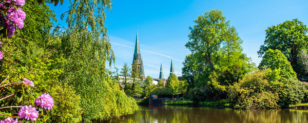 Canvas Print - View of the pond and St. Lamberti Church of Oldenburg, Germany.