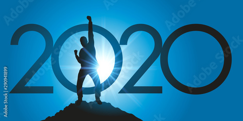 Fotomural Carte de voeux 2020 montrant un homme satisfait en levant le poing en signe de la victoire après avoir atteint son objectif en arrivant au sommet d’une montagne