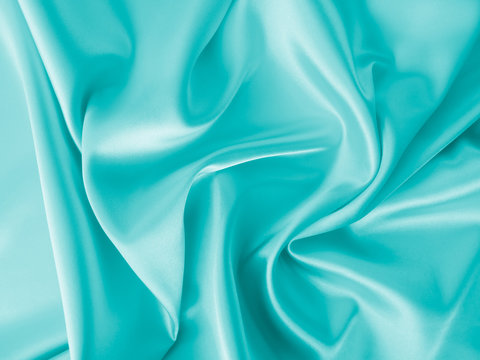 Wall Mural - Smooth elegant wavy turquoise blue silk or satin luxury cloth fabric texture, abstract background design.