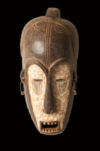 An African Ceremonial Mask In The Form Of A Female Figure Carved In Wood Isolated On Black.