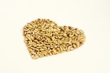 Heart shaped peeled seeds on white background