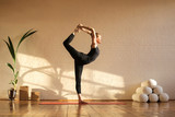 Beautiful woman doing yoga at sunset time in a studio