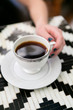 © Deidre - Girl holding cup of coffee in antique cup at cafe, close up, copy space