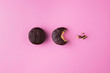 Creative concept of chocolate sandwich cookies or macaroons bite on pastel pink color background.Food inspiration idea.Top view,flat lay.Horizontal orientation