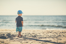 Toddler Boy Walking On A Sunny Beach