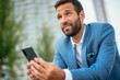 © JustLife - Businessman using smart phone in the street