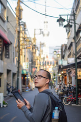 Wall Mural - a man holding a tablet /mobile phone while using online map or searching the destination on internet