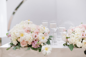 Poster - Stylish decoration of the modern wedding table with white candles and flowers in light shades.