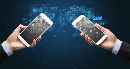 Close up of two hands holding smartphones to sync business data