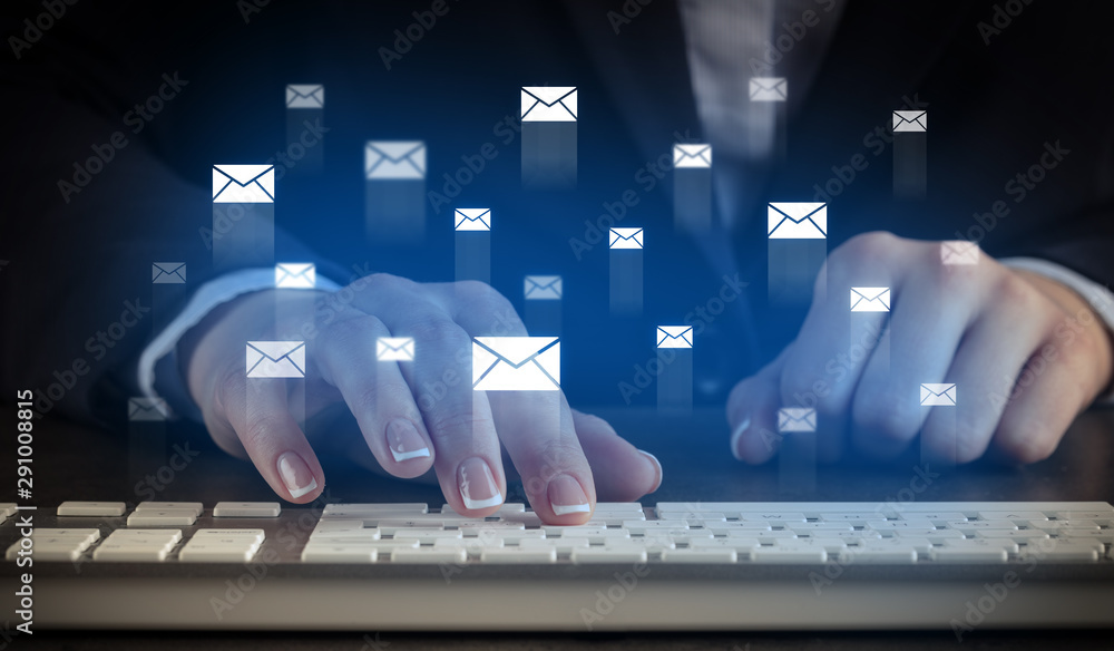 Business woman typing on keyboard with mail icons around - obrazy, fototapety, plakaty 