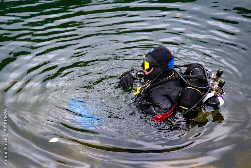 the-diver-is-ready-to-dive-into-the-water-a-man-in-a-wetsuit-and-scuba