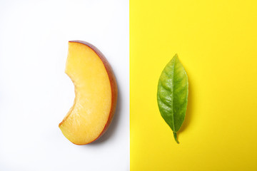 Flat lay composition with ripe peach and leaf on color background