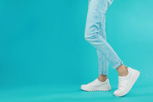 Woman In Stylish Sport Shoes On Light Blue Background. Space For Text
