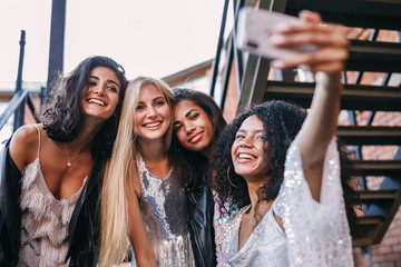 Wall Mural - Happy friends taking a selfie. Women making a photo on cell phone.