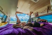 Interior View Of A Couple Relaxing On Their Bed In A Camper Van