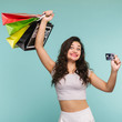 Funny woman with multicolored packages on a yellow background, shopping