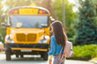 schoolgirl is waiting for a school bus