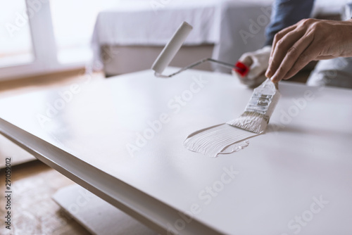 Cuadros en Lienzo Man painting wooden door with paintbrush