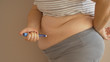 Overweight woman applying diabetes medicine injection into her belly