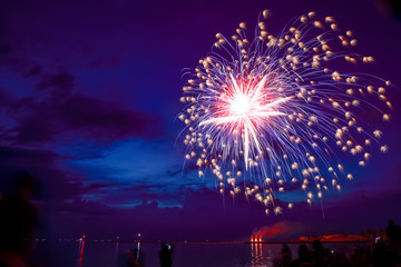 Fireworks over lake michigan at dusk, motion blur on people, long exposure