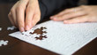 © Benjavisa Ruangvaree - hand pick a piece of jigsaw to connect success on wooden table top selected focus