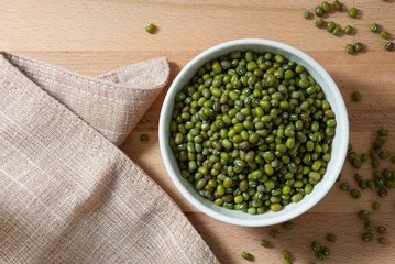 Wall Mural - Top View of Green Mung Beans in a White Bowl on Wooden Table