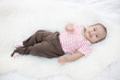 © Johnstocker - happy baby lying on white bed