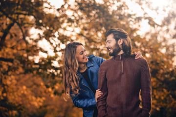 Couple in autumn season colored park enjoying outdoors.