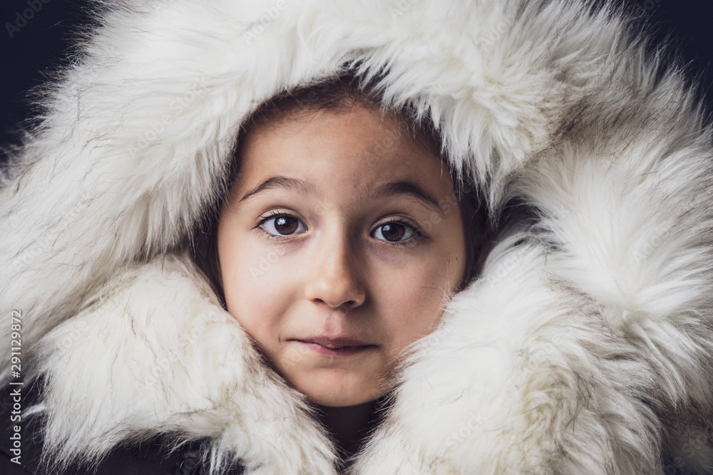 Close up portrait of a young girl dressed with an eskimo jacket  looking at the camera - obrazy, fototapety, plakaty 