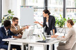 © LIGHTFIELD STUDIOS - multiethnic businesspeople at table with laptops during conference in office