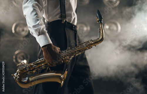 Obraz Dibond Czarny muzyk jazzowy z saksofonem na scenie