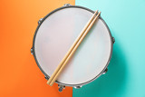 Drum stick on color table background, top view, music concept