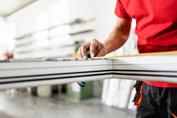 Wall Mural - Manual worker assembling PVC doors and windows. Manufacturing jobs. Selective focus. Factory for aluminum and PVC windows and doors production.