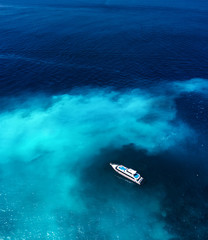 Wall Mural - fast boat at the sea in bali, indonesia. aerial view of luxury floating boat on transparent blue wat