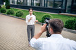 © LIGHTFIELD STUDIOS - selective focus of attractive journalist holding microphone and cameraman shooting her outside