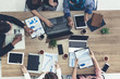 © InfiniteFlow - Top view of businessman executive in group meeting with other businessmen and businesswomen in modern office with laptop computer, coffee and document on table. People corporate business team concept.
