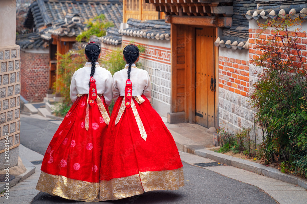 Korean lady in Hanbok or Korea dress and walk in an ancient town in seoul - obrazy, fototapety, plakaty 