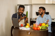 © liliyabatyrova - Two man using laptop in kitchen