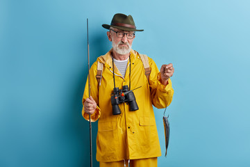 Wall Mural - depressed old man is crying . he couldn't catch many fish, close up photo. isolated blue background, studio shot