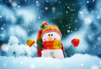 Wall Mural - little snowman on soft snow on blue background