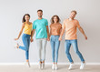 © Pixel-Shot - Group of jumping young people in stylish casual clothes near light wall