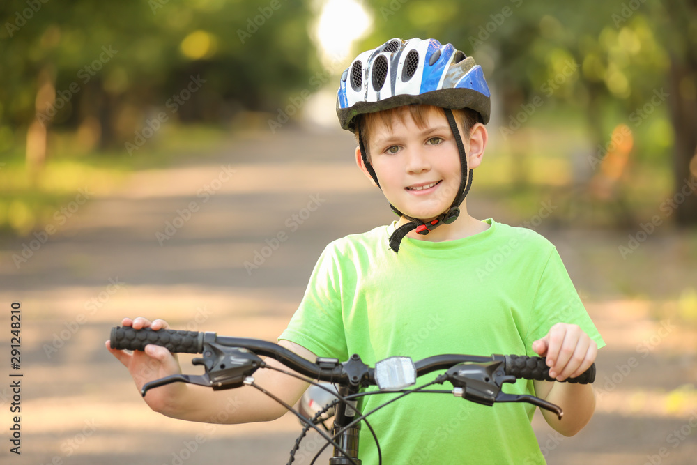Cute boy riding bicycle outdoors
