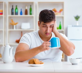 Canvas Print - Man falling asleep during his breakfast after overtime work