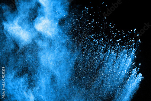 Blue powder explode cloud on black background. Launched blue dust particles s...