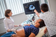 © Nejron Photo - Pregnant woman and her son on utltrasonographic examination at hospital