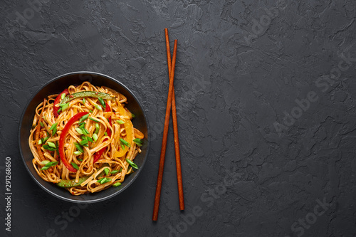 Fotografía Vegetarian Schezwan Noodles or Vegetable Hakka Noodles or Chow Mein in black bowl at dark background